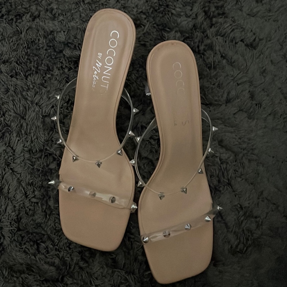 Clear strappies with silver spikes on a tan sole.